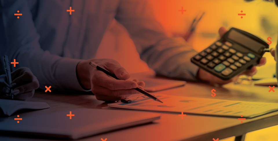 Des papiers sur un bureau avec les mains d'une personne tenant une calculatrice.